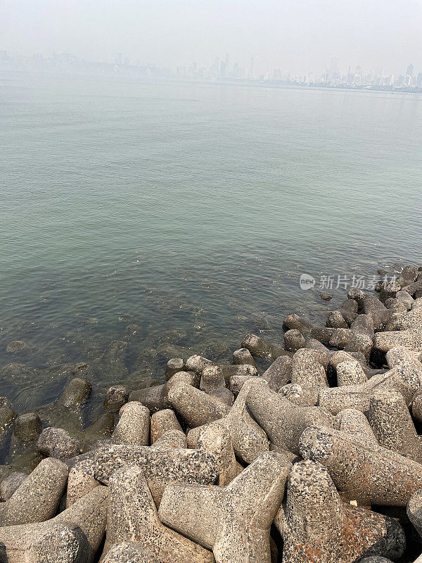 印度孟买的Marine Drive海堤特写图像，环环相扣，混凝土，四足块海防，海岸管理，防止侵蚀，海水和海浪，高架视图，重点放在前景上